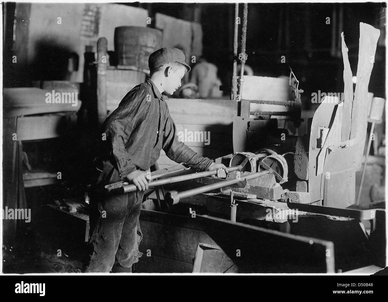Eine Mitternachtsszene aus dem November 1909 in einer Glasfabrik in New Jersey, die Arbeiter am „Glory Hole“ zeigt, einem Ofen, in dem Glas erhitzt wurde. Dieses Bild zeigt die Arbeitsbedingungen der Industrie im frühen 20. Jahrhundert. Stockfoto