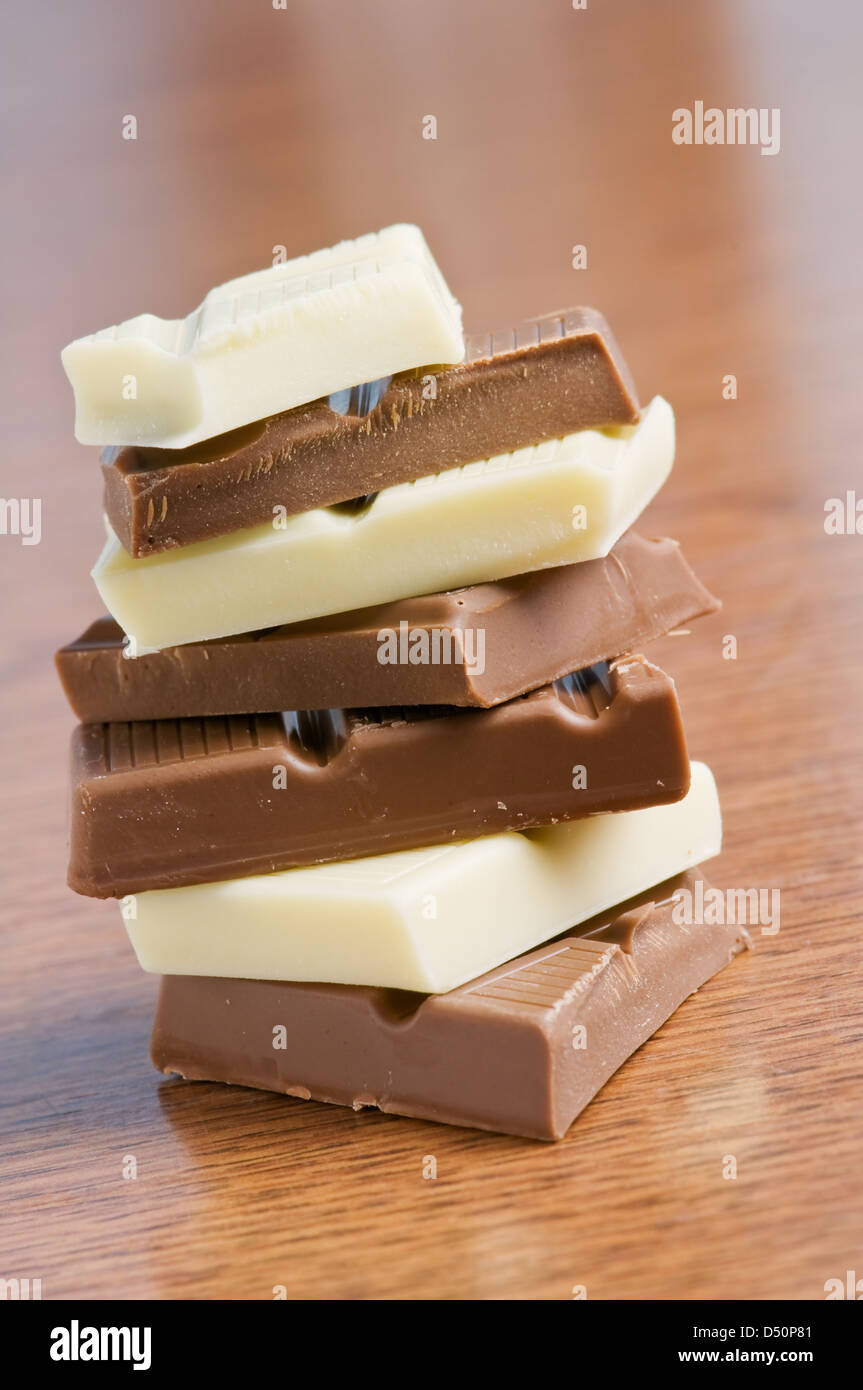 Schokoladenstücke auf Holztisch Stockfoto