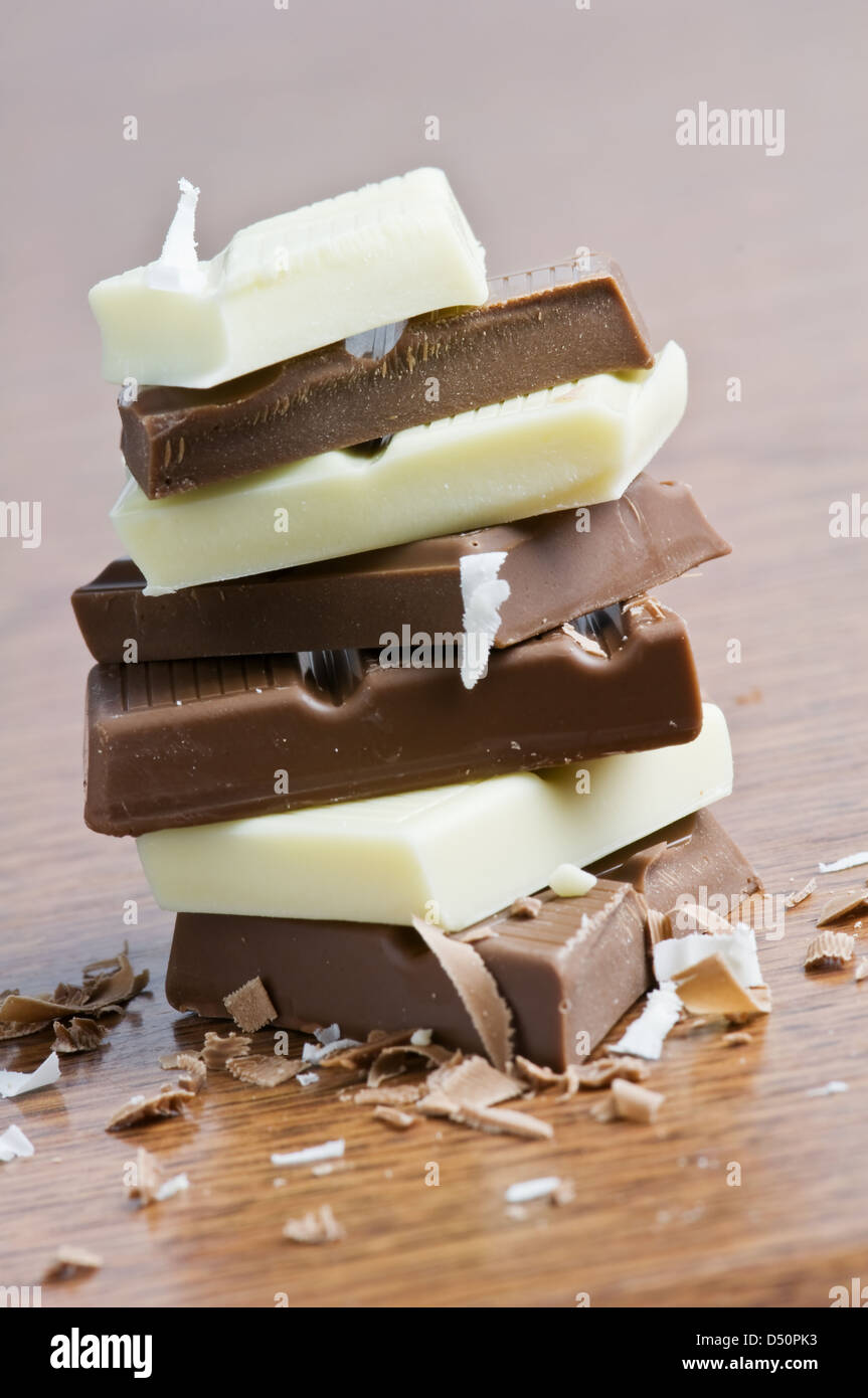 Schokoladenstücke auf Holztisch Stockfoto