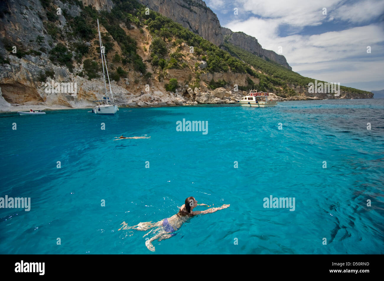 Touristen genießen die klare und transparente Wasser des Golfs von Orosei, an der Küste in der Nähe von Cala Mariolu Strand, Baunei, Sardinien, Italien Stockfoto