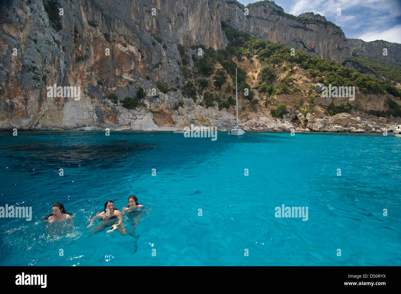Touristen genießen die klare und transparente Wasser des Golfs von Orosei, an der Küste in der Nähe von Cala Mariolu Strand, Baunei, Sardinien, Italien Stockfoto