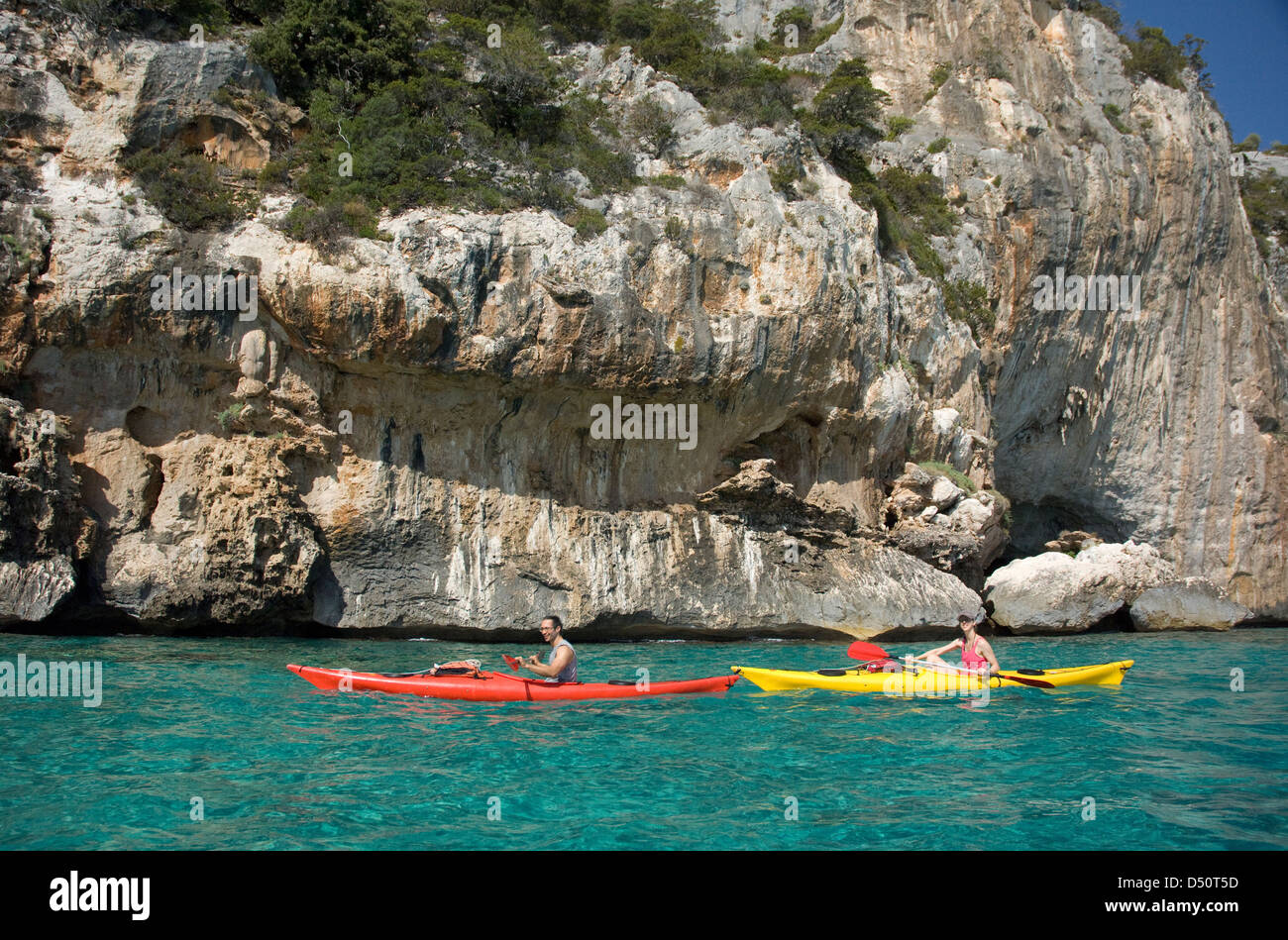 Touristen auf Kajaks Segeln entlang der Klippen und das klare Wasser des Golfs Cala Luna Küste, Cala Gonone, Orosei, Sardinien, Italien Stockfoto
