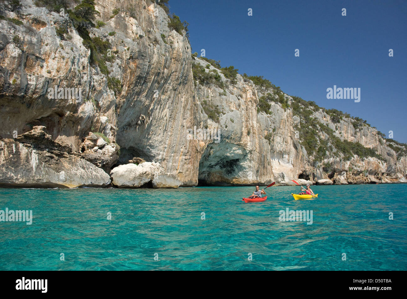 Touristen auf Kajaks Segeln entlang der Klippen und das klare Wasser des Golfs Cala Luna Küste, Cala Gonone, Orosei, Sardinien, Italien Stockfoto