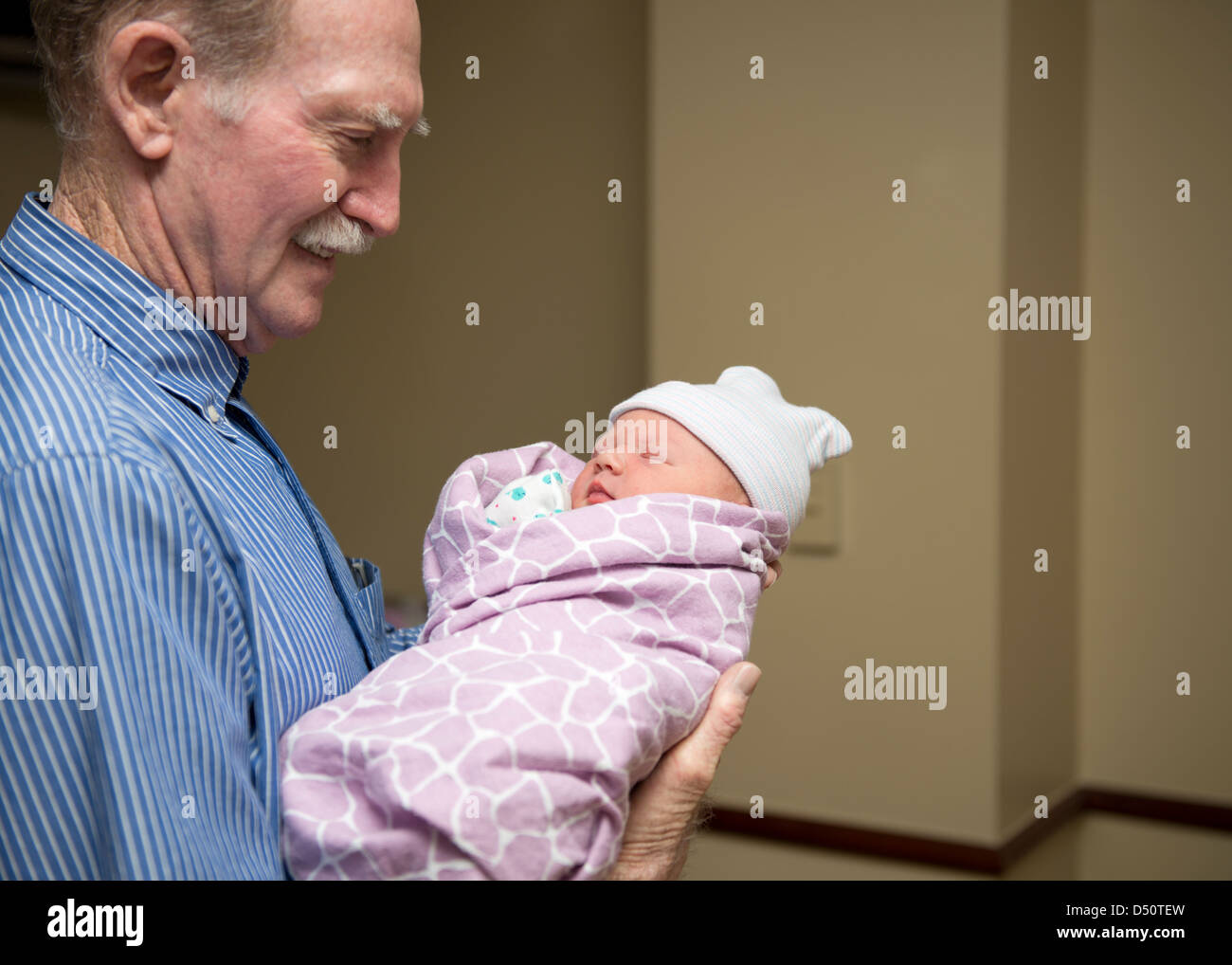 Ein neugeborenes Mädchen, nur 16 Stunden alt ist von ihrem Urgroßvater gehalten, seine erste große Enkelkind. USA. Stockfoto