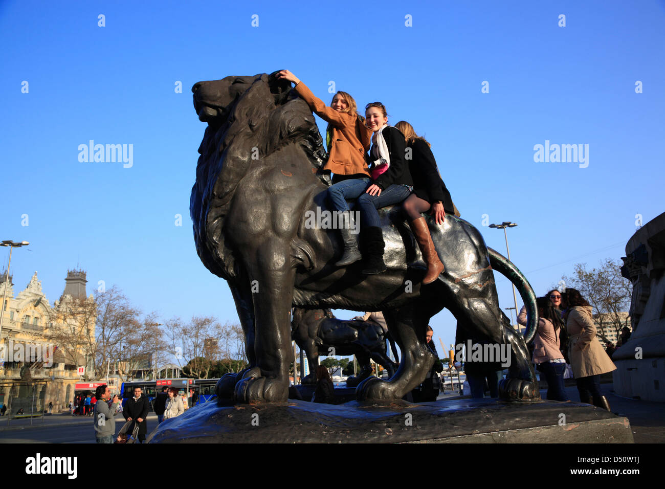 Junge Menschen auf einem Löwen am Plaça Portal De La Pau am Hafen, Barcelona, Spanien Stockfoto