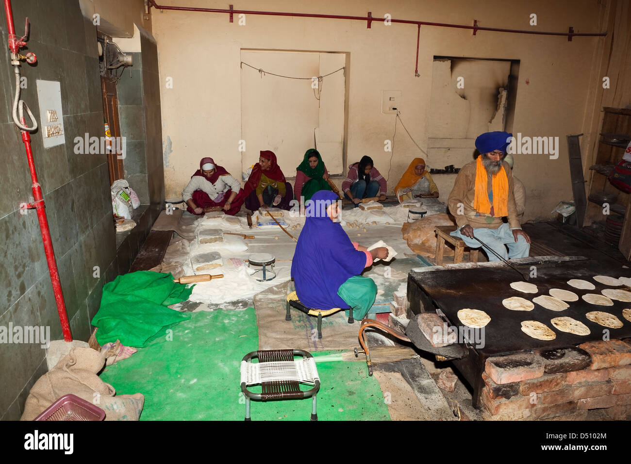 Männer und Frauen Sikh freiwillige machen und Kochen Chapattis in der freien Küche innerhalb der Golden Tempel Komplex Amritsar Punjab Indiens Stockfoto
