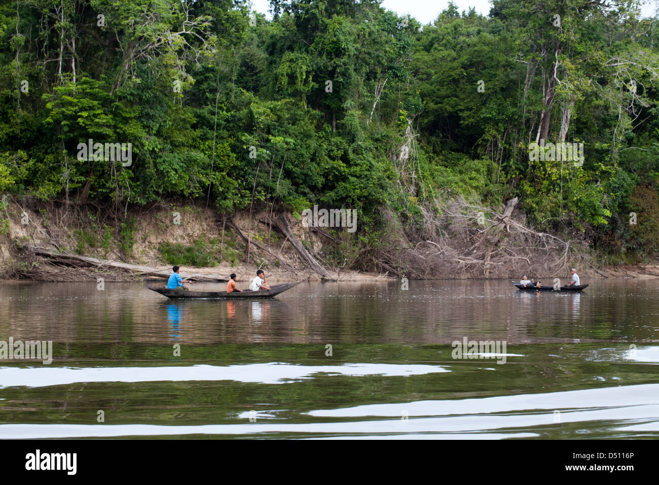 Gegraben, Kanus im Einsatz von Amerindian Dorfbewohnern, Angeln auf Linie und Haken über die Seite. Wald Bäume bis hinunter zu den Stockfoto