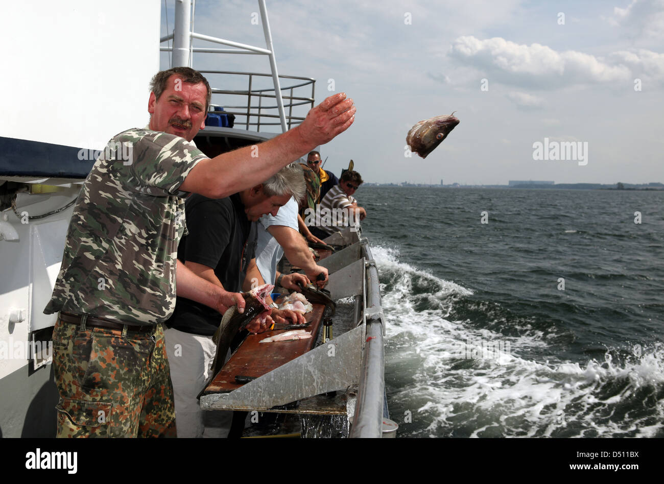 Wismar, Deutschland, wirft Mann das Hochseefischen ein Fischkopf im Wasser Stockfoto