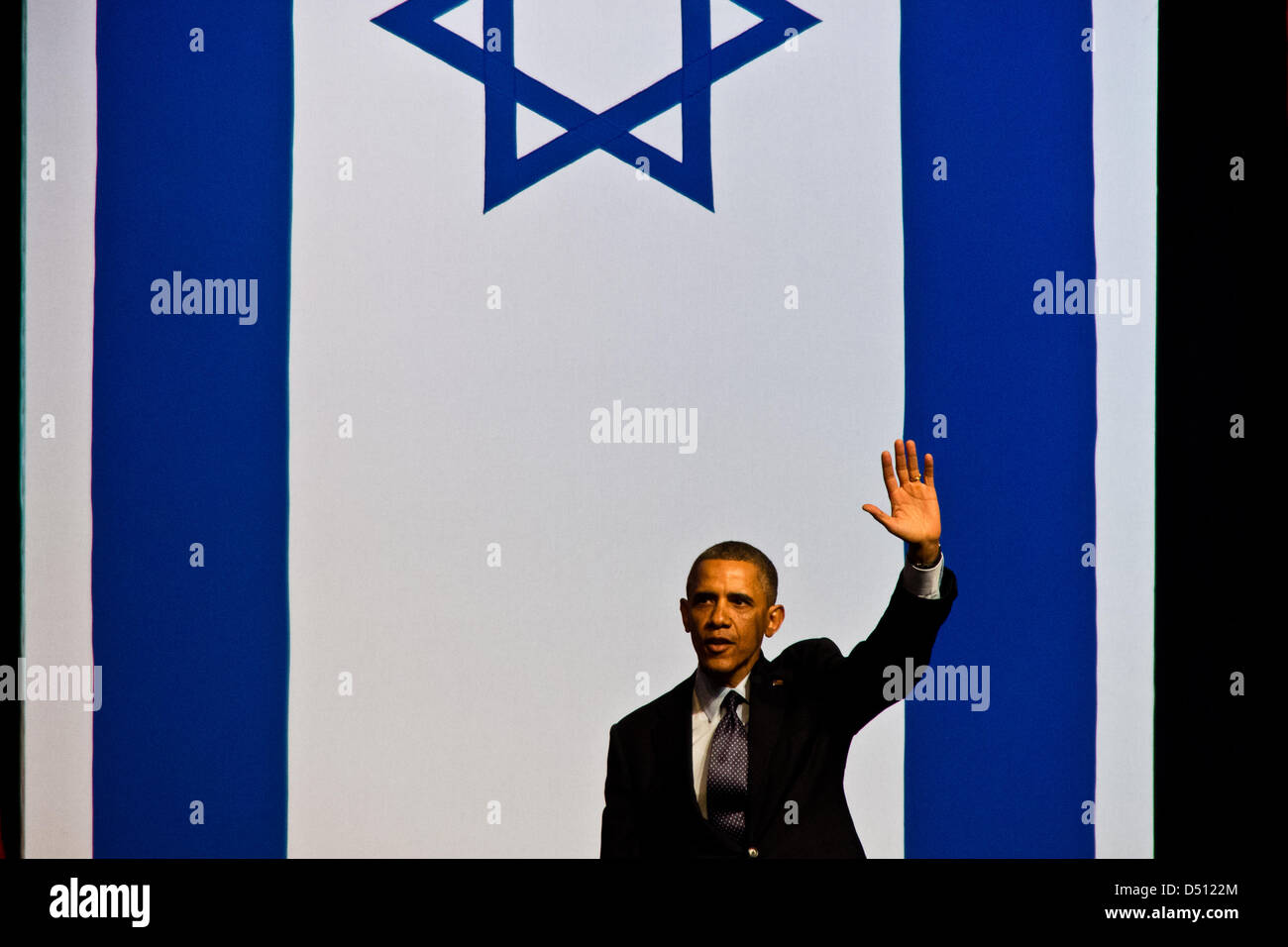 Verlassen der Bühne und winken auf Wiedersehen im folgenden ist die Lieferung einer öffentlichen Adresse, US-Präsident Barack Obama die israelische Flagge umrahmt. Jerusalem, Israel. 21. März 2013.  US-Präsident Barack Obama richtet sich Hunderte von jungen Studenten in Israel in Jerusalem International Convention Center. Diesen Schülerinnen und Schülern sprechen Obama umgeht Politiker mit einer Botschaft des Friedens und ist herzlich willkommen mit Standing Ovations. Stockfoto