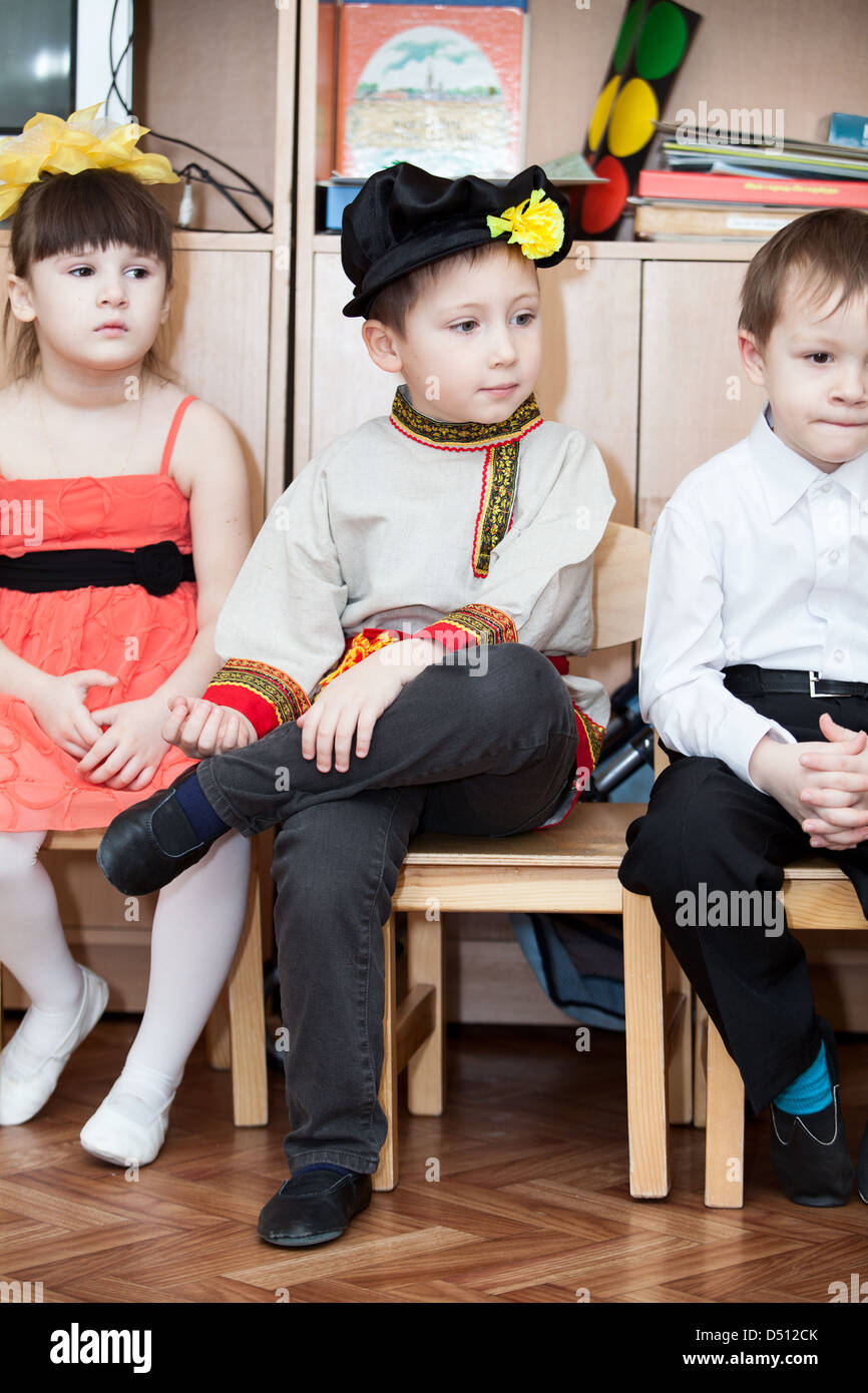 Süße Jungs in russische traditionelle Kleidung im Kindergarten sitzen auf  Stühlen im Klassenzimmer. Russland Stockfotografie - Alamy