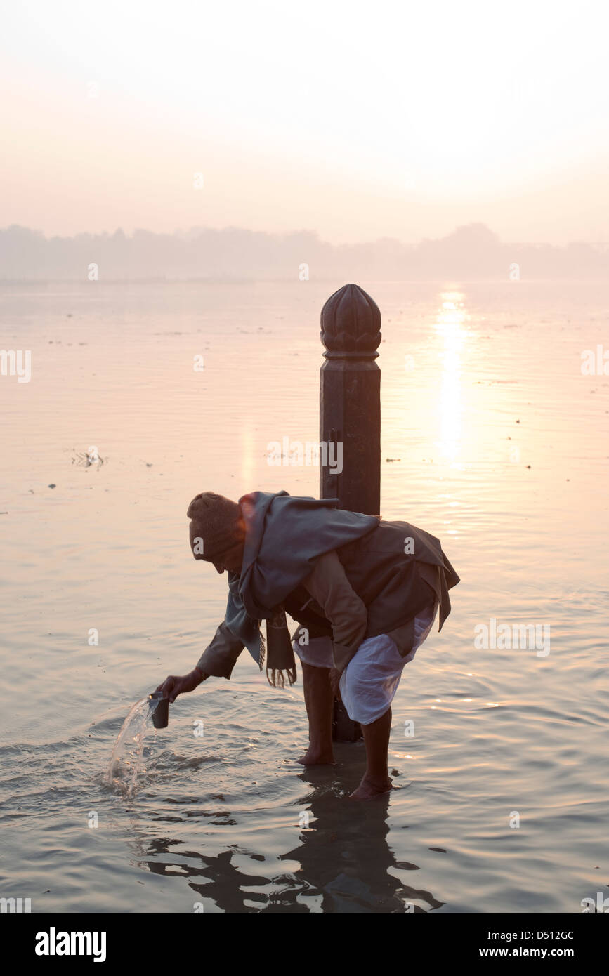 Ein Hindu Anhänger führt ritueller Praktiken im Fluss Yamuna bei Sonnenaufgang am Vishram Ghat, Mathura, Uttar Pradesh, Indien Stockfoto
