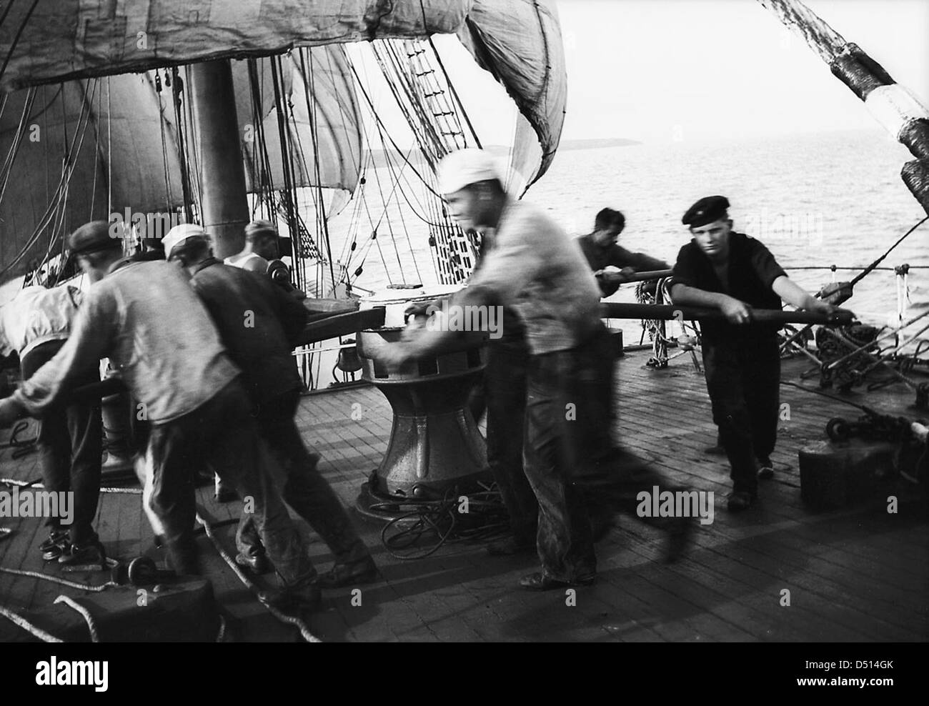 Dieses Foto zeigt die Besatzung des Schiffes „Parma“, die an der Lande arbeitet und sich darauf vorbereitet, den Anker zu wiegen. Das Bild wurde vom National Maritime Museum aufgenommen und spiegelt die traditionellen maritimen Praktiken von Segelschiffen und die notwendige Teamarbeit für den Schiffsbetrieb auf See wider. Stockfoto