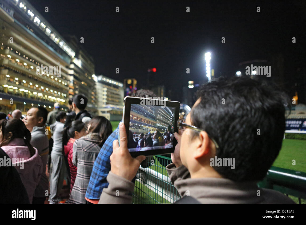 Hong Kong, China, Mann filmt mit seinem Tablet-PC an die Happy Valley Racecourse Stockfoto