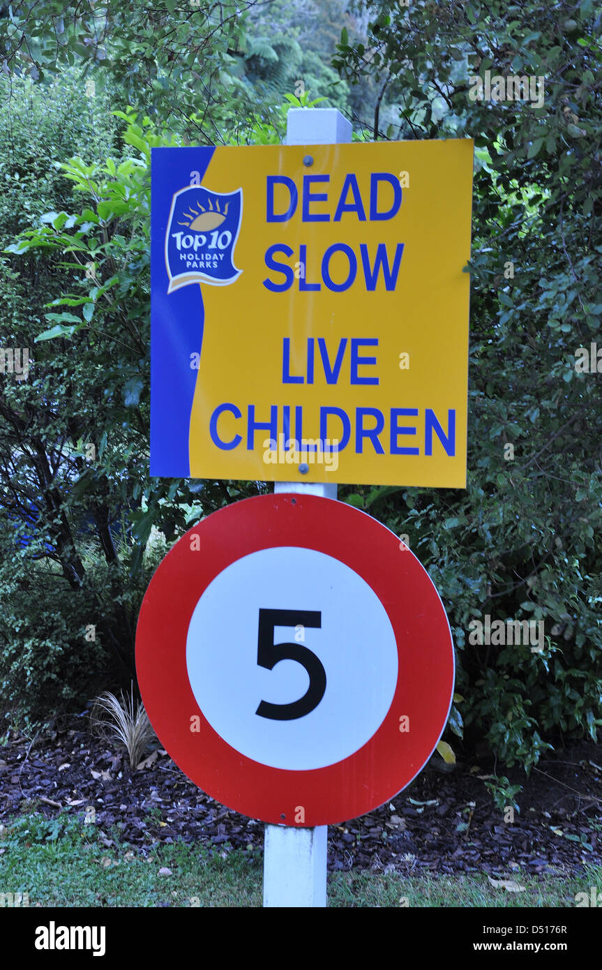 Ein Schild in einem Neuseeland-Campingplatz besagt 'Dead Slow - Leben Kinder' und maximale Geschwindigkeit von 5 km/h Stockfoto