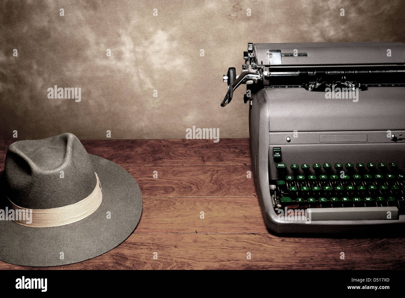 Einer alten Vintage Schreibmaschine mit einem Reporter Fedora Hut auf einem Holztisch mit Platz für Kopie. Stockfoto