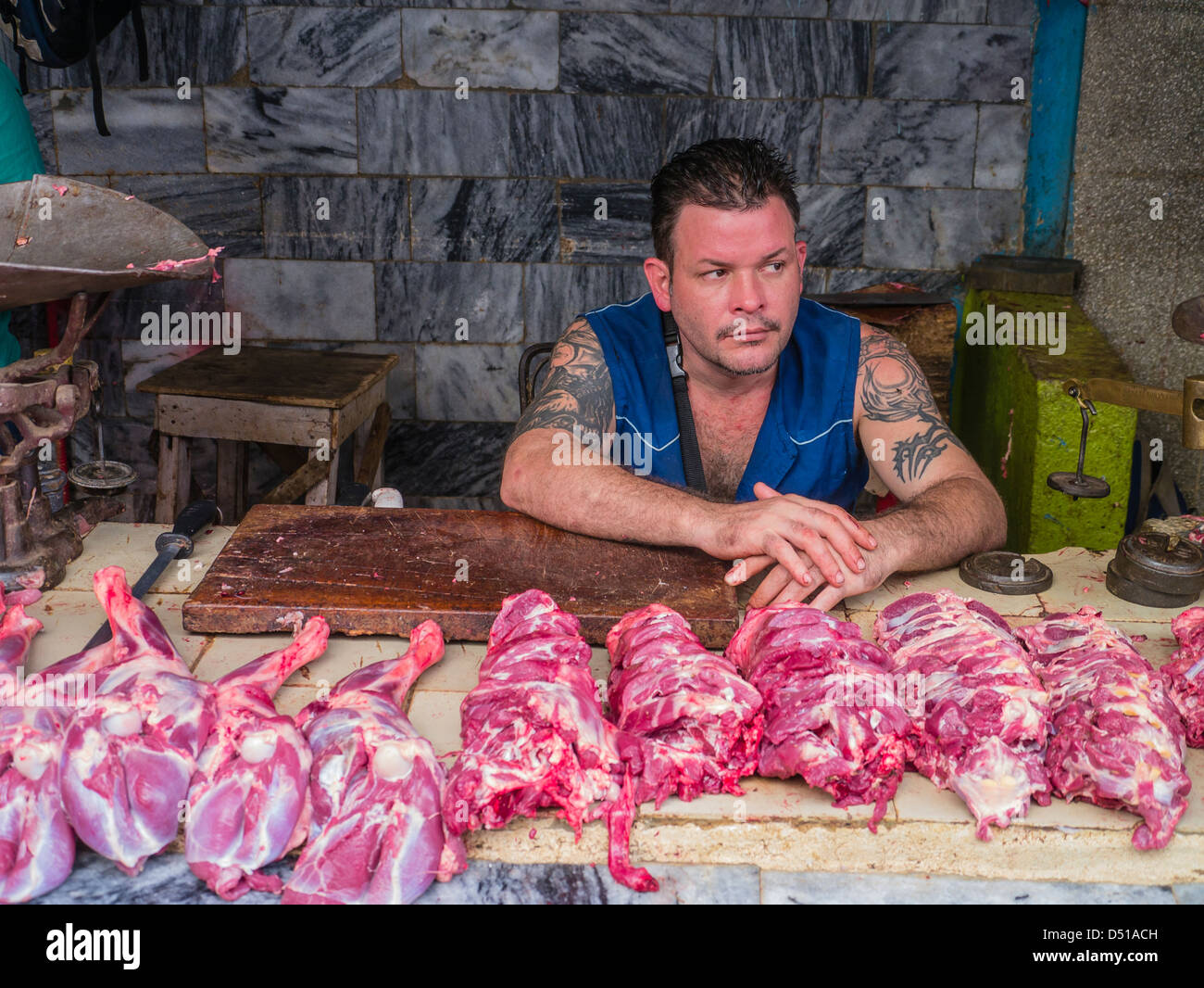 Ein kubanische Metzger sitzt hinter seinem Tisch Fleisch zum Verkauf auf einem freien Markt in Havanna, Kuba. Stockfoto