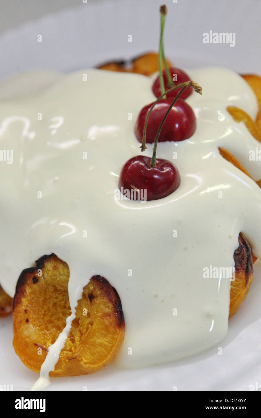 Gegrillte Pfirsiche mit Zabaione Dessert mit Kirschen Stockfoto