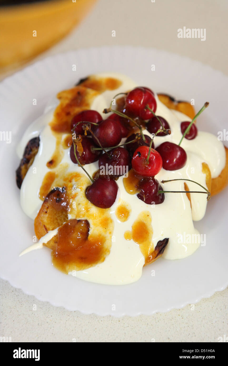 Gegrillte Pfirsiche mit Zabaione Dessert mit Kirschen und Marmelade Stockfoto
