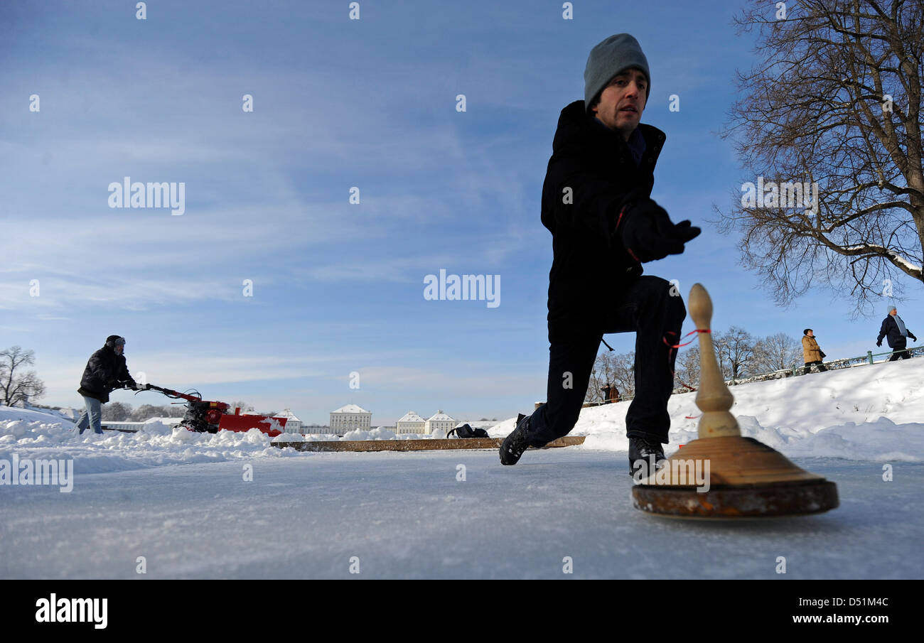 Ein Mann wirft die Stein während eines Spiels Curling in München, 26. Dezember 2010. Foto: Andreas Gebert Stockfoto