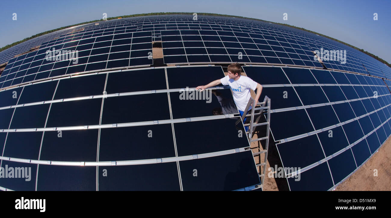 (Dpa Datei) - ein Datei Bild, datiert 21. April 2009, zeigt Techniker Karsten Dahns Inspektion der Oberfläche eines montierten Solarpanels auf dem ehemaligen Truppenübungsplatz in Lieberose, in der Nähe von Cottbus, Deutschland. Nach einem Boom im Bereich solar-Geschäft im Jahr 2010 glauben Experten jetzt, dass Preise in der Solarbranche im Jahr 2011 einen Sektor sinken könnte die stark Supsidies mit Rechnung wurde Stockfoto