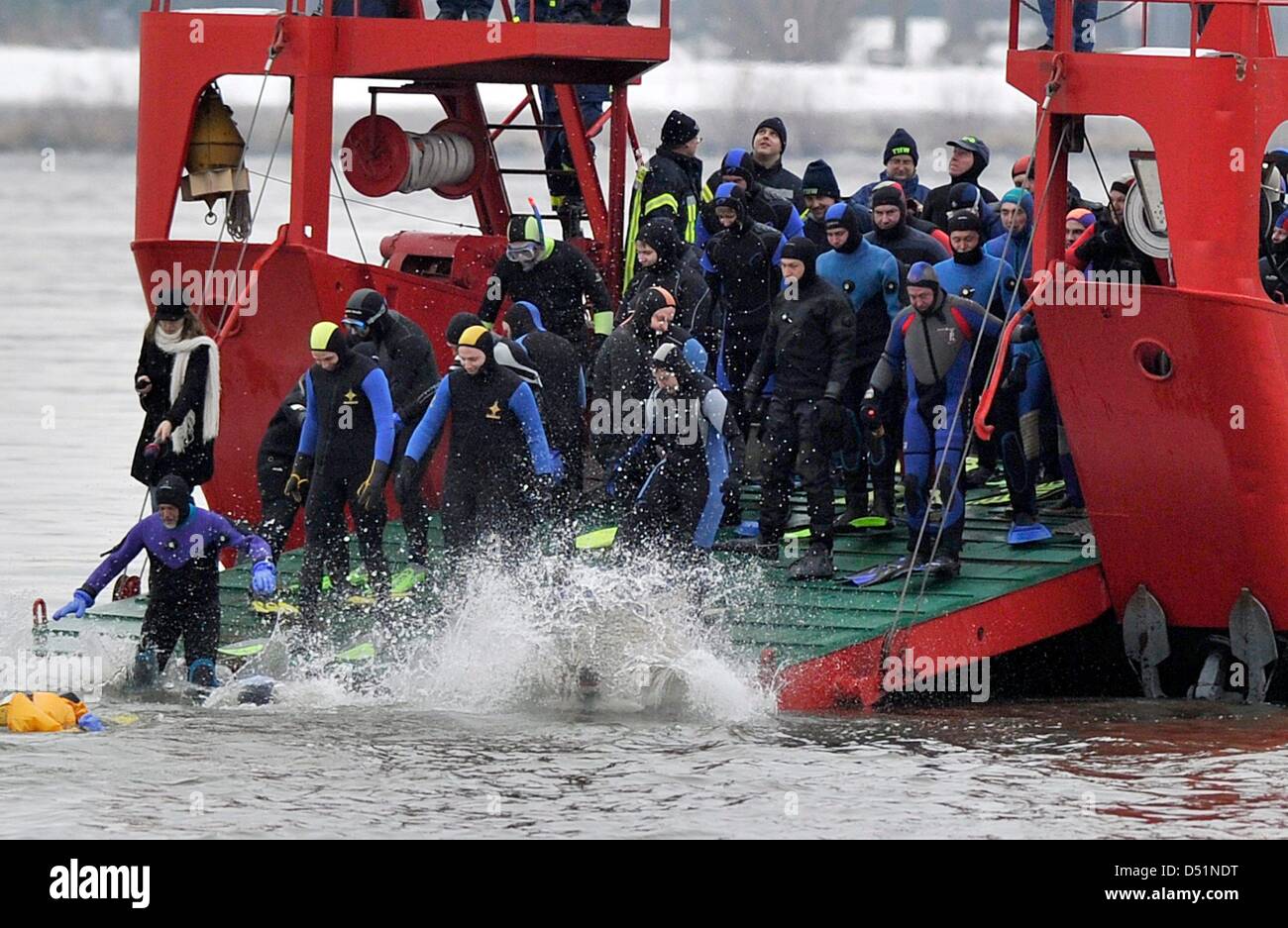 Mit einem Sprung vom Bug eines Bootes Fire Deparment stürzte mehr als 160 Rettungstaucher, Polizisten und Feuerwehrleute in die eiskalten Fluten des Rheins für die Feuerwehr traditionelle Silvester-schwimmen in Mainz, Deutschland, 31. Dezember 2010. Sie waren etwa zwei Kilometer von der Strömung tragen. Foto: Boris Roessler Stockfoto