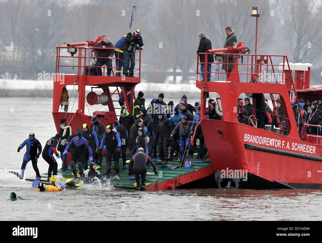 Mit einem Sprung vom Bug eines Bootes Fire Deparment stürzte mehr als 160 Rettungstaucher, Polizisten und Feuerwehrleute in die eiskalten Fluten des Rheins für die Feuerwehr traditionelle Silvester-schwimmen in Mainz, Deutschland, 31. Dezember 2010. Sie waren etwa 2 Kilometer von der Strömung tragen. Foto: Boris Roessler Stockfoto