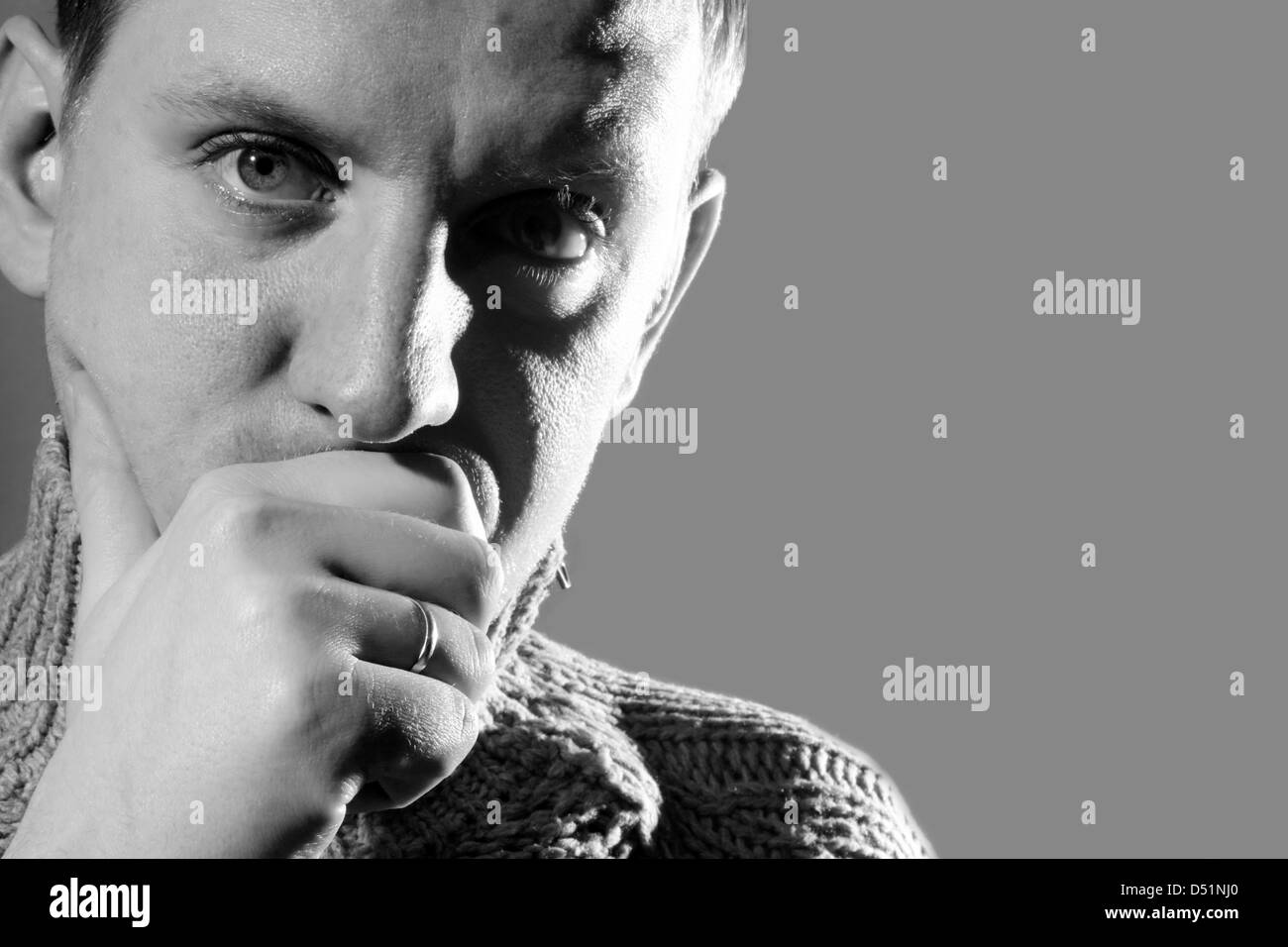 nachdenklicher junger Mann, Blick in die Kamera, schwarz / weiß Stockfoto