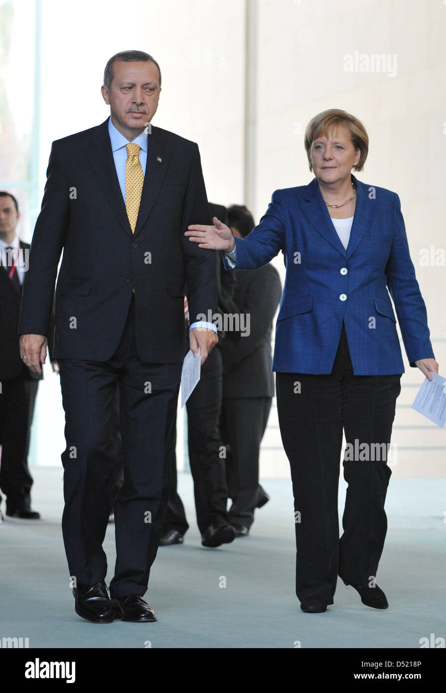 Bundeskanzlerin Angela Merkel bremst der türkische Ministerpräsident Recep Tayyip Erdogan auf dem Weg zu einer gemeinsamen Pressekonferenz nach einem Treffen im Kanzleramt in Berlin, Deutschland, 9. Oktober 2010. Merkel wollte mit dieser Geste Übersetzer geben Zeit, ihren Messestand zu betreten. Merkel will den 50. Jahrestag des Abkommens zwischen Deutschland und der Türkei Konze Rekrutierung Stockfoto