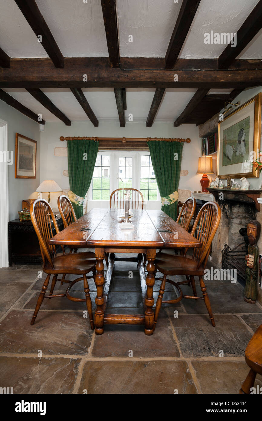Einen Zeitraum cottage Esszimmer mit Holzbalken an der Decke und einem Steinboden. Stockfoto