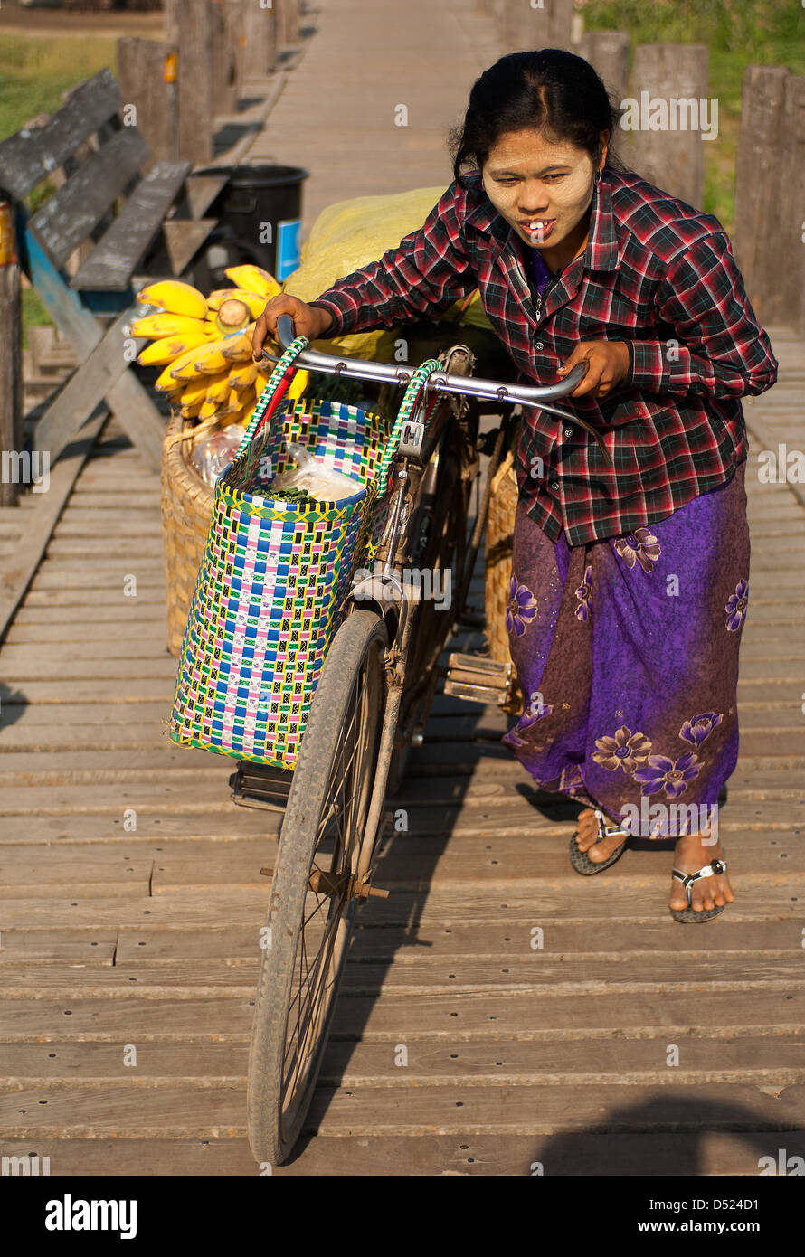 Eine Frau drückt ihr Fahrrad über U-Klangkunst-Brücke in Mandalay, Myanmar, auf 1.300 Yards die weltweit längste Teakholz Fußgängerbrücke. Stockfoto