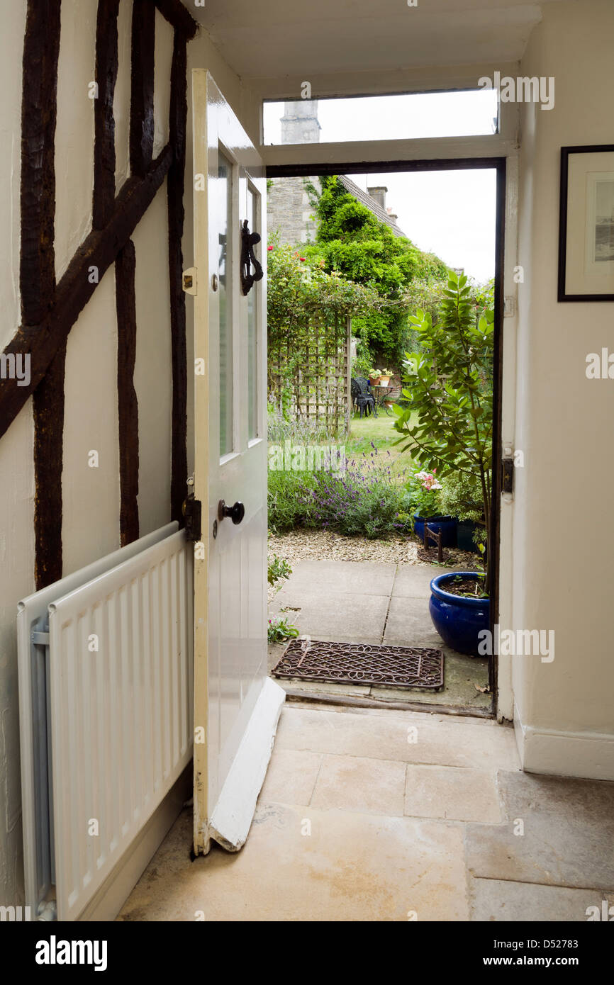 Eine offene Tür für einen Zeitraum cottage Suchen von innen heraus auf einen Garten. Stockfoto