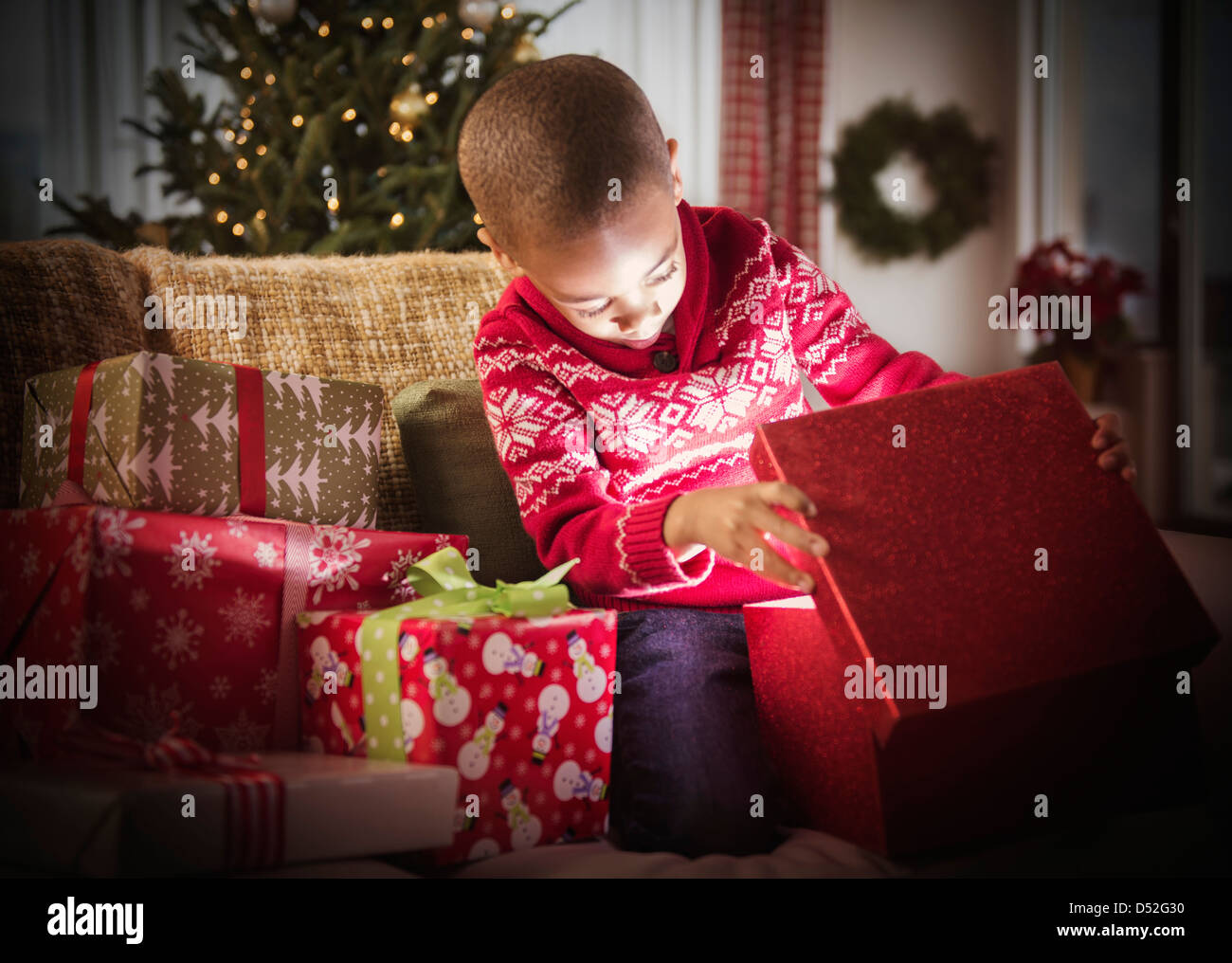 African American Boy Eröffnung Weihnachtsgeschenke Stockfoto