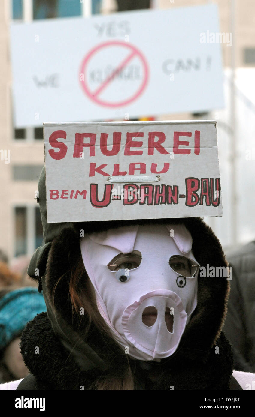 Eine Frau mit einer Schweine Maske lesen in Englisch "Was für eine Sauerei, Diebstahl auf der u-Bahn-Baustelle" bei einer Demonstration gegen angeblichen Pfusch beim Bau der Kölner neue u-Bahnlinien in Köln, 3. März 2010. Köln markiert den Zusammenbruch seiner historischen Stadtarchiv genau vor einem Jahr mit einer Schweigeminute. Herr Bürgermeister Roters lud Hinterbliebene, ar Stockfoto