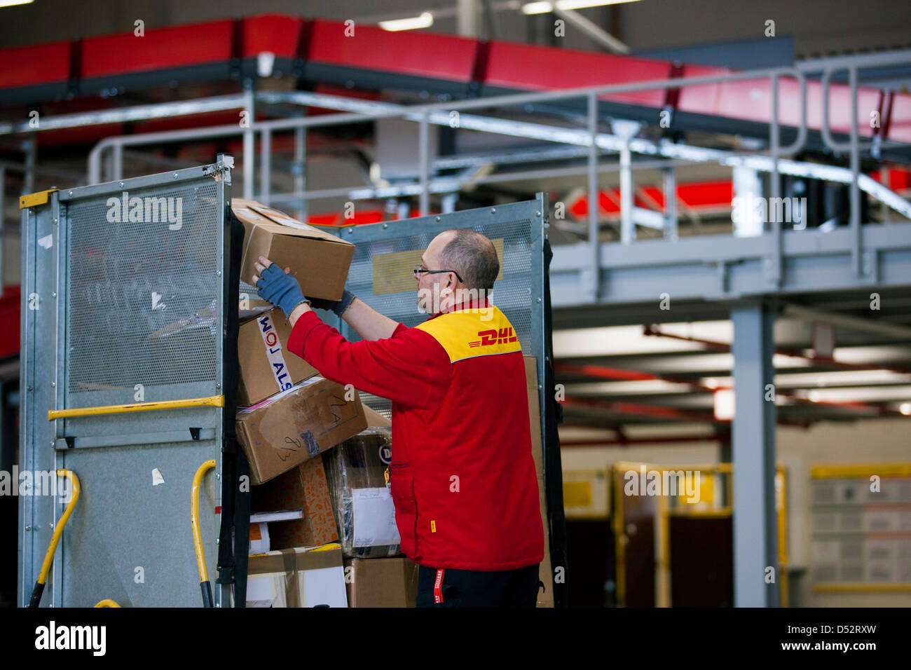 Ein Mitarbeiter von Deutsche Post DHL legt eine Paket auf einem Wagen bei  der ersten mechanischen Abgabestelle in Bochum, Deutschland, 20. März 2013.  Es ist das zweite bundesweite System, das die Pakete
