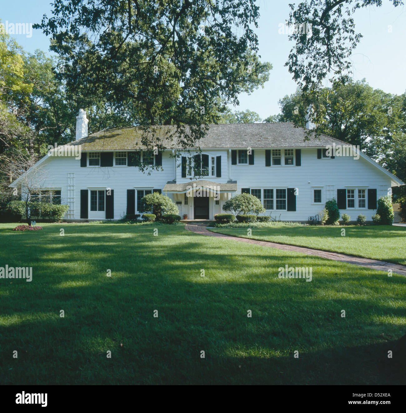 Fassade des traditionellen weißen Holzhaus mit großer Liegewiese Stockfoto