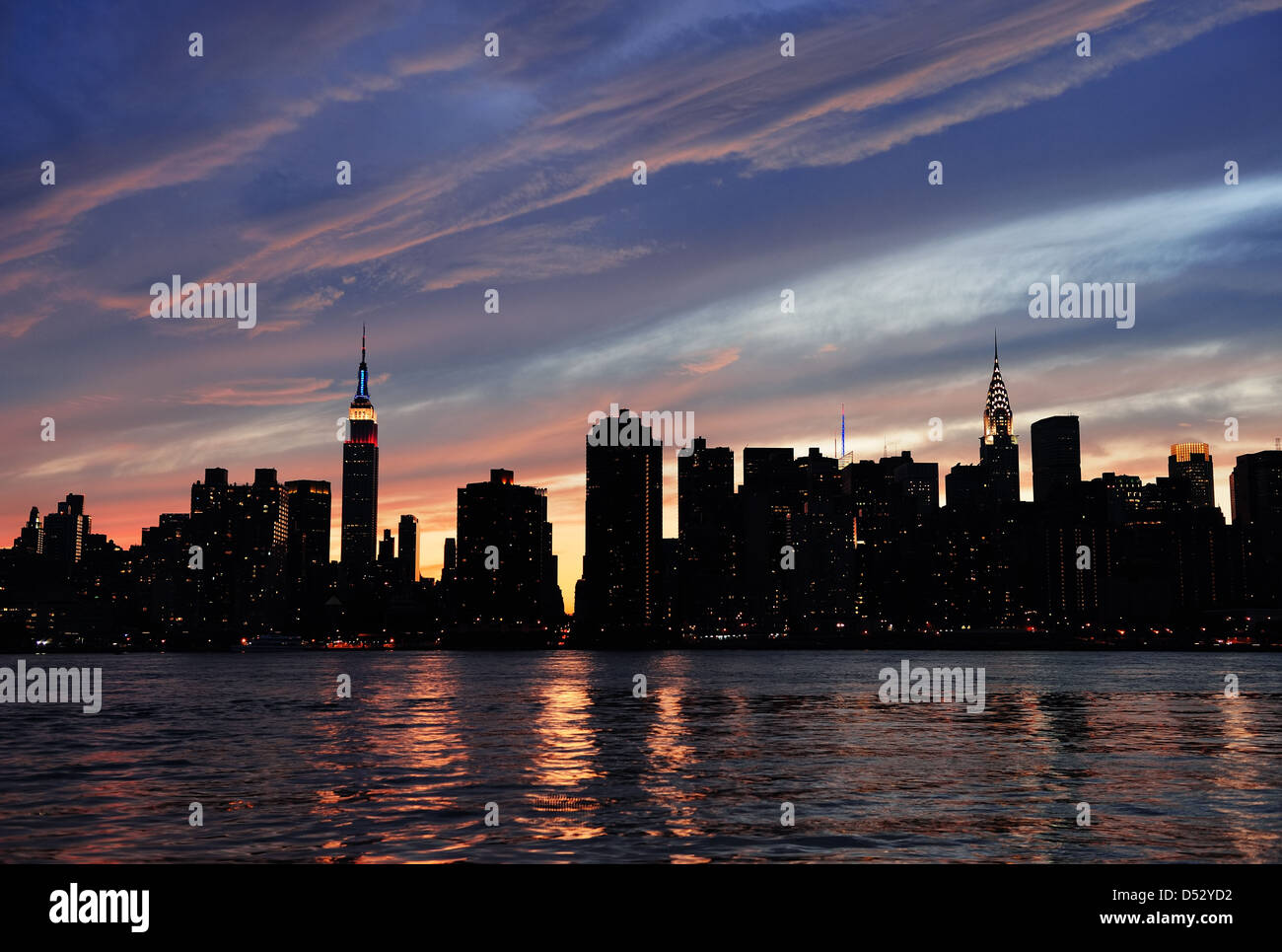 New York City Manhattan Midtown Silhouette Panorama bei Sonnenuntergang mit Wolkenkratzern und bunten Himmel über East river Stockfoto