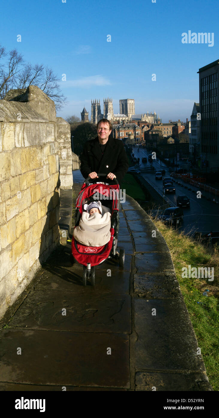 Ein Mann mit Kinderwagen auf York Stadtmauer mit dem Münster über  Stockfotografie - Alamy