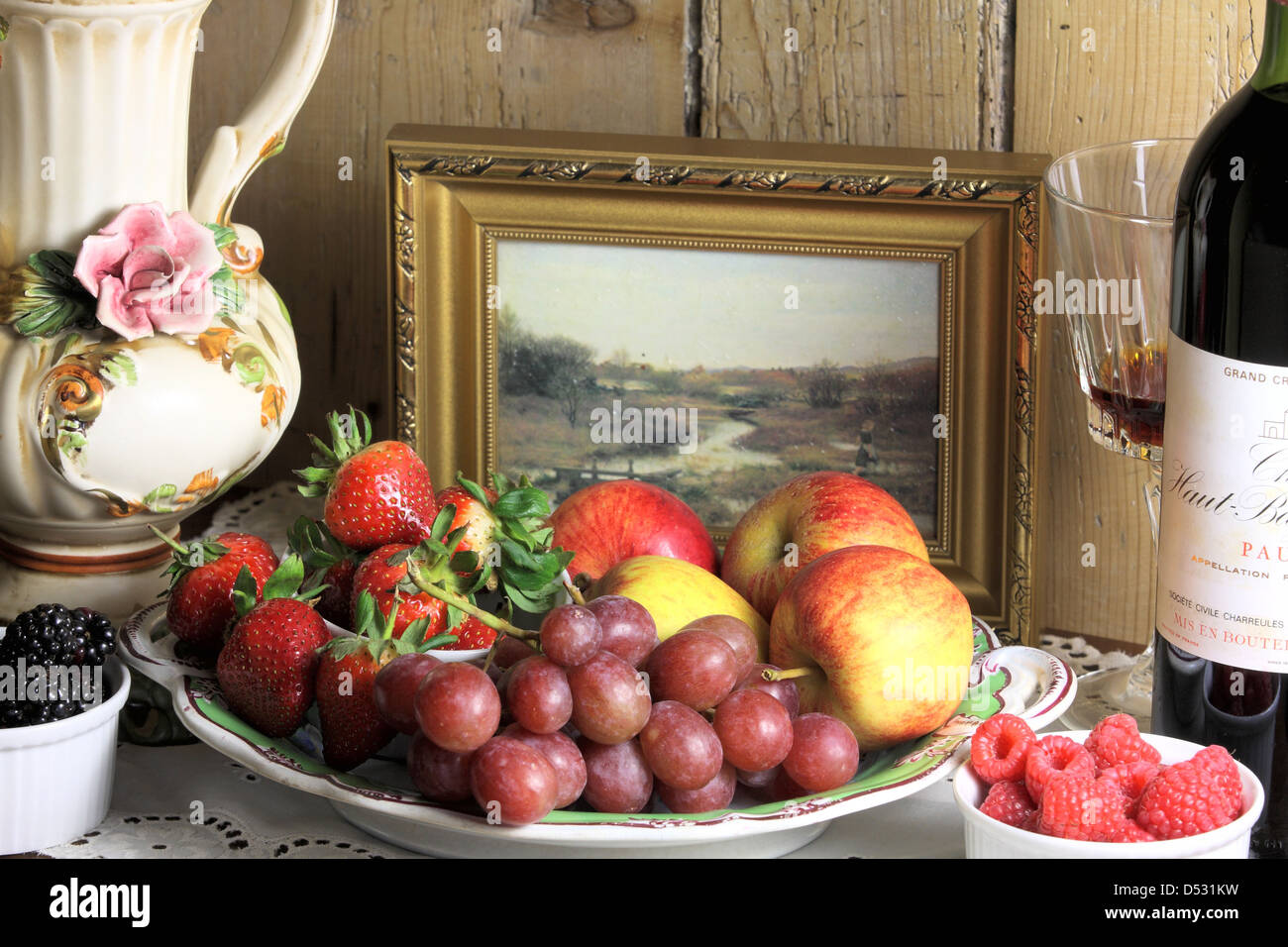 ein Stillleben Foto von Obst, Beeren, Vase und Wein Flasche Stockfoto