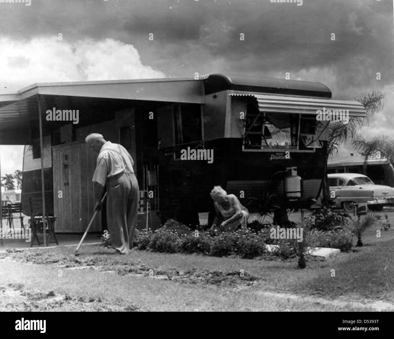 Ein unbekanntes Paar arbeitet in ihrem Hof bei Trailer Estates in Sarasota, Florida. Das Bild spiegelt die Gemeinschaft und den Lebensstil der Bewohner des Wohnwagenparks wider und unterstreicht die Kultur der Outdoor-Erholung und Gartenarbeit. Stockfoto