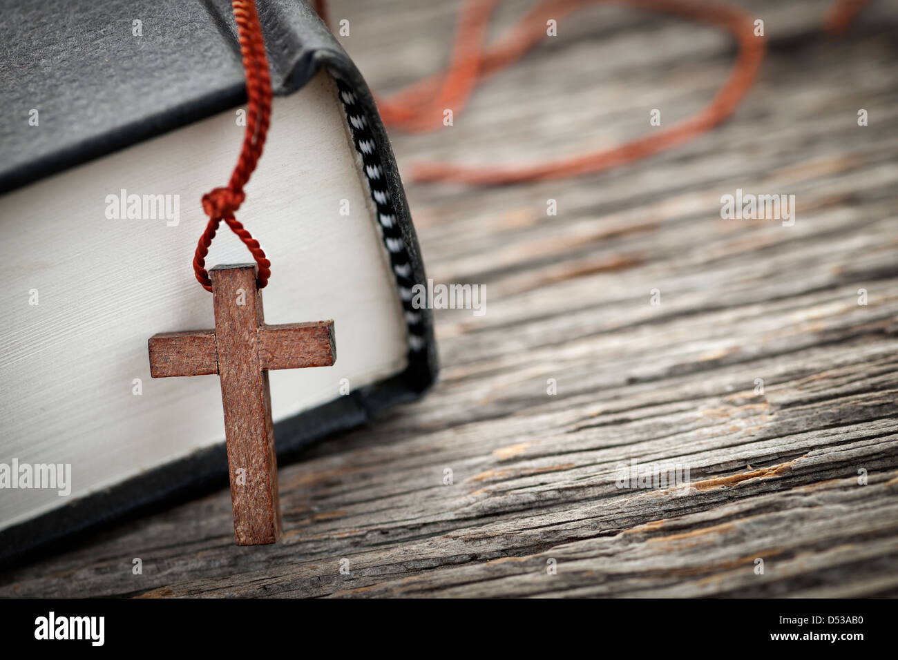 Nahaufnahme des hölzernen Christian Kreuz Halskette neben Bibel Stockfoto