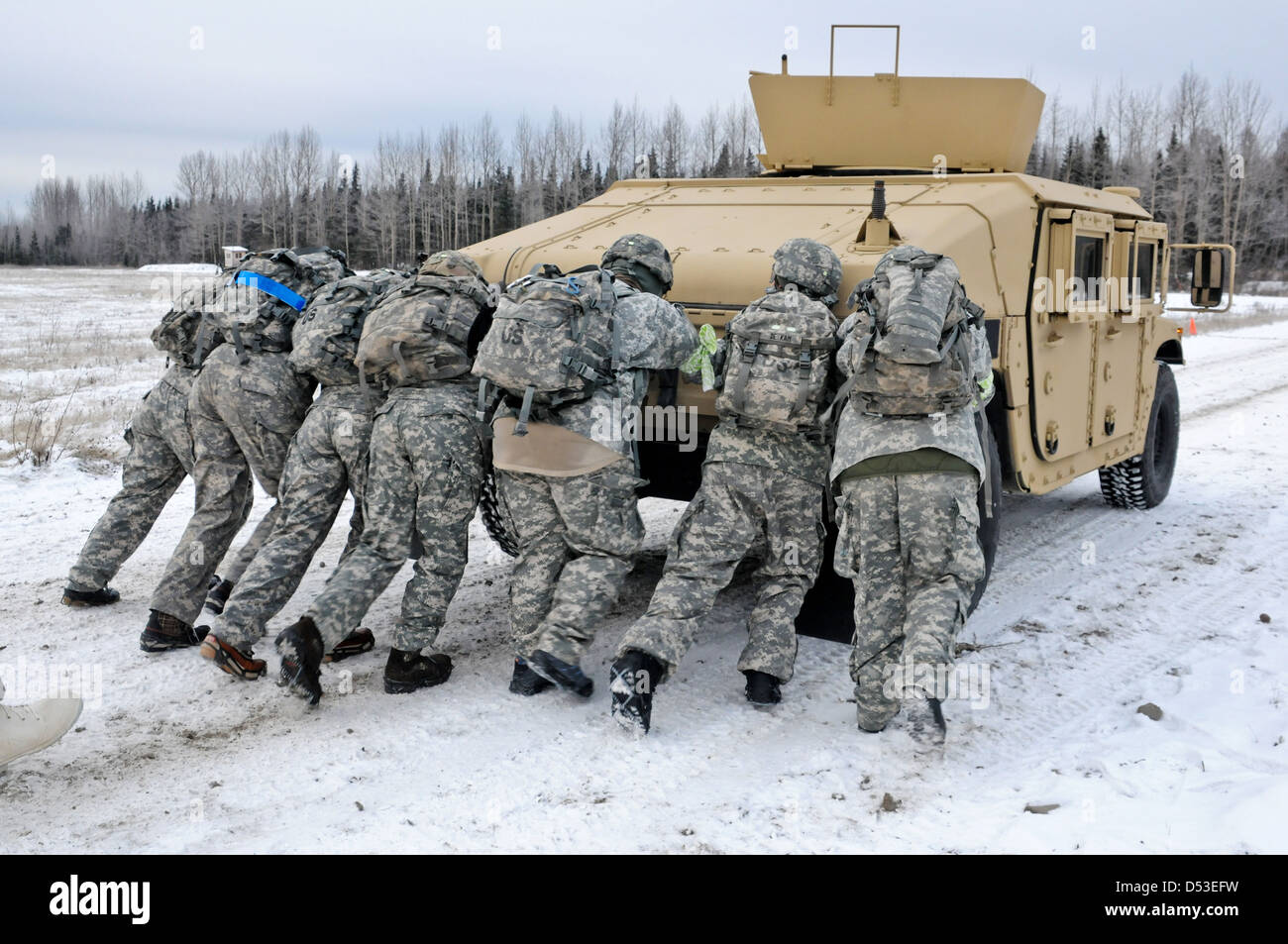 Ehegatten, gekleidet in Schlacht Strapazen schieben einen Humvee-Jeep während der Arktis G.I Jane Day-Aktivitäten 8. November 2012 auf gemeinsamer Basis Elmendorf-Richardson, Alaska. Der Tag kann Ehegatten, einige der Ausbildung zu erleben, die ihre Soldaten durchlaufen. Stockfoto