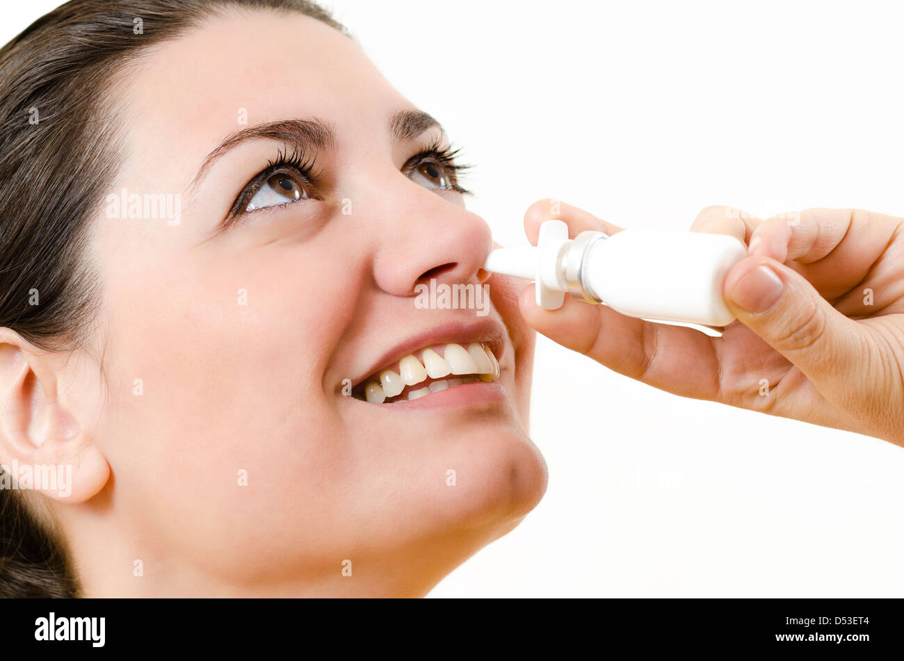 Eine glückliche Frau, die mit Nasenspray Stockfoto