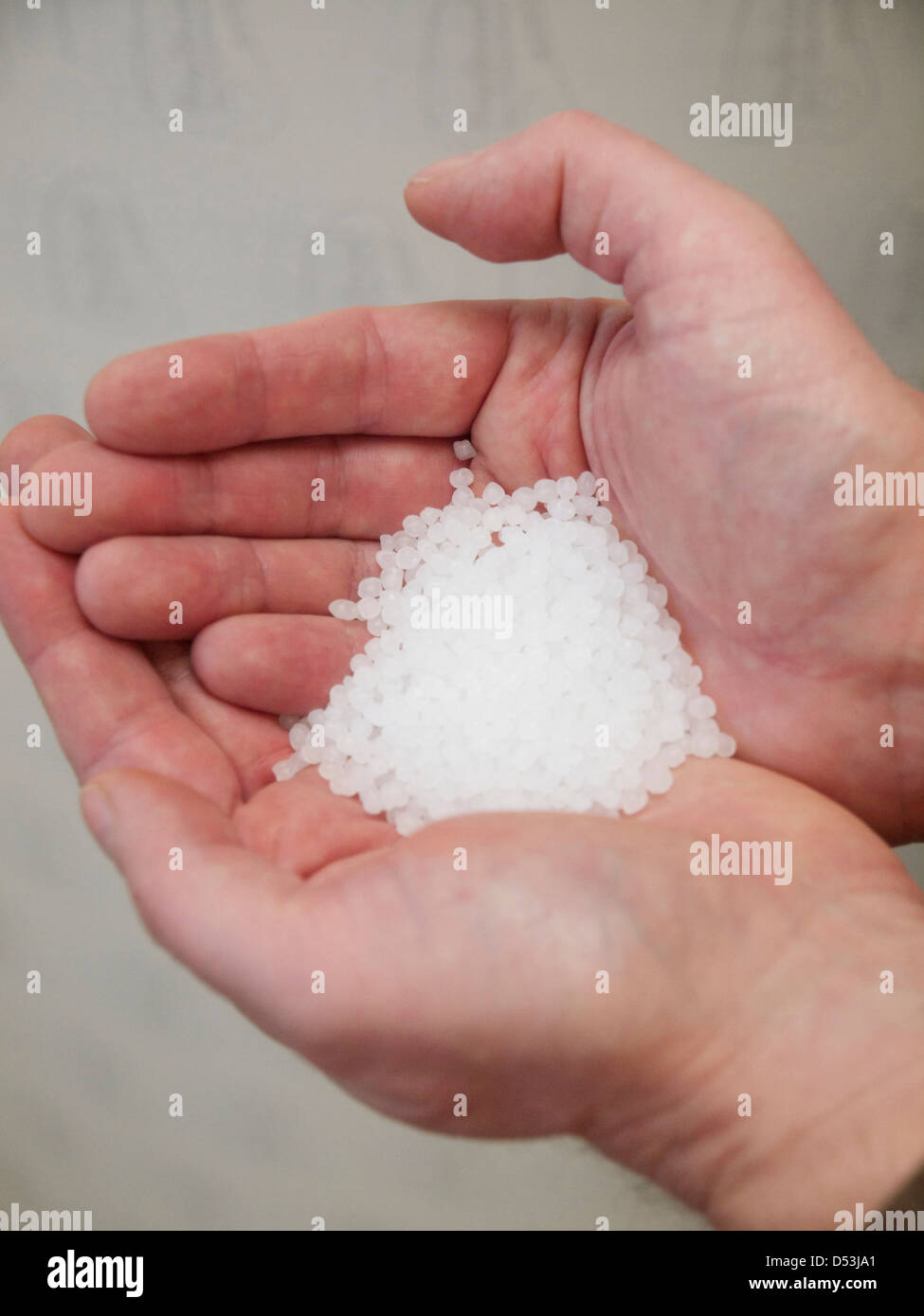 Hände halten Poly-Ethylen-Granulat Stockfoto