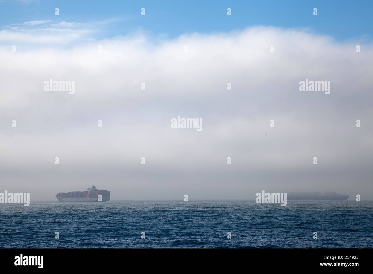 Container-Schiffe vor der Küste in Kapstadt durch den Nebel - Südafrika Stockfoto