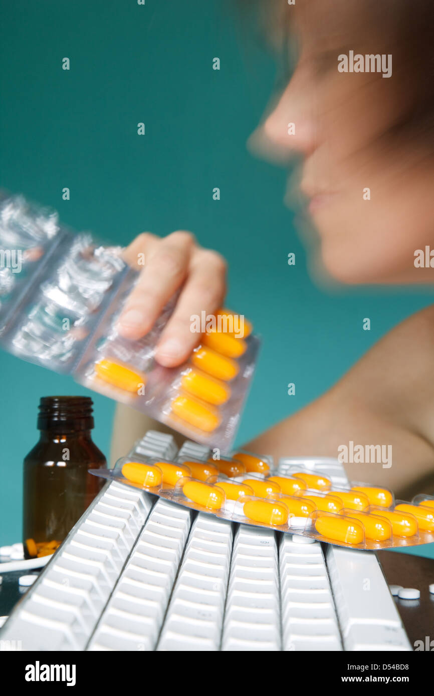 Berlin, Deutschland, nimmt eine Frau Tabletten bei der Arbeit Stockfoto