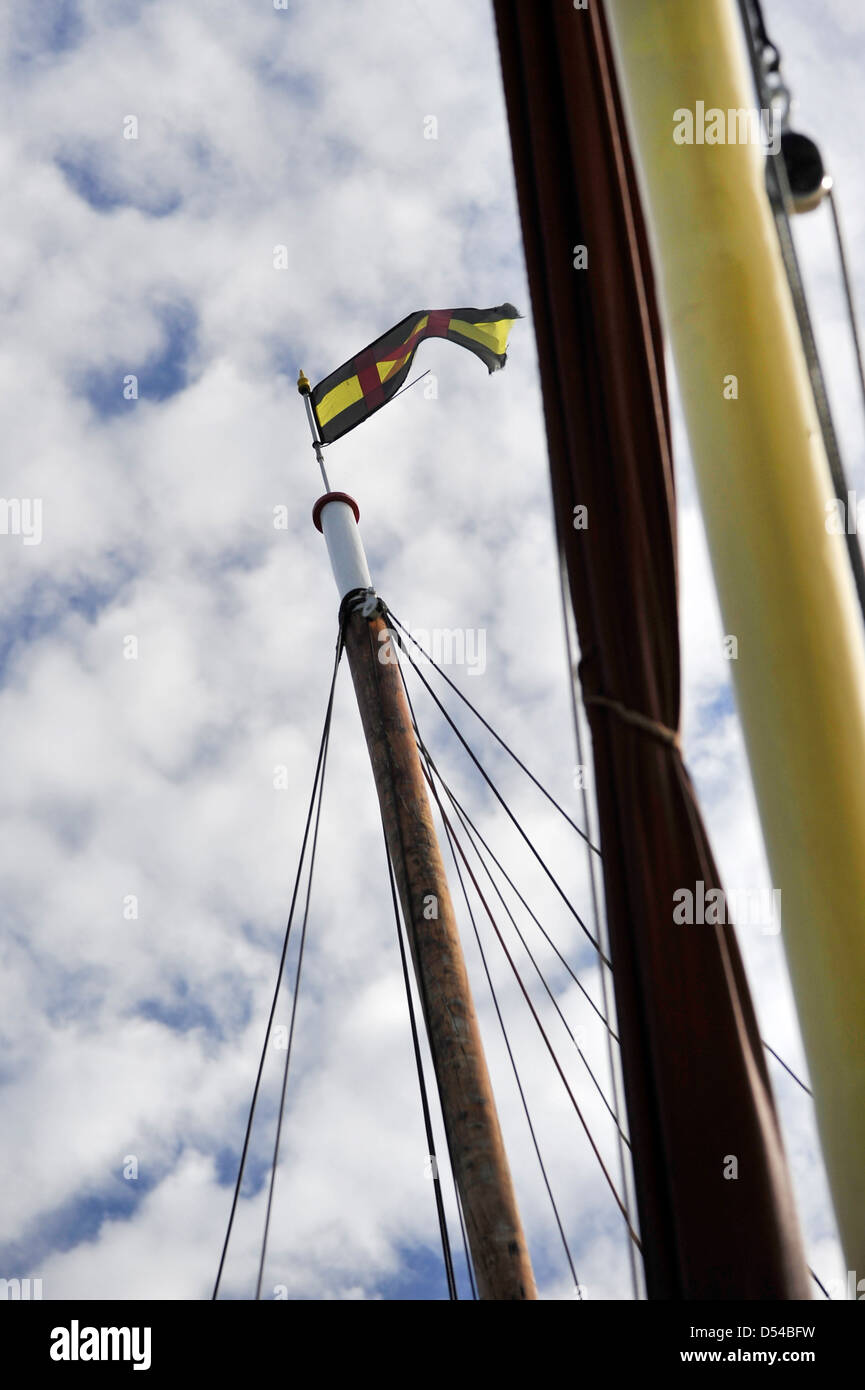 Gesehen von unten eine Schiffe Mast und Flagge gegen ein bewölkter Himmel Stockfoto
