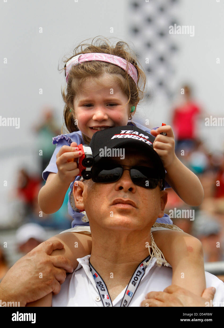 24. März 2013 - St. Petersburg, Florida, US - DIRK SHADD |   Zeiten. Mikaella Castroneves, 3, die Tochter von IndyCar Treiber Helio Castroneves, spielt mit Spielzeug-Autos während auf den Schultern von Helio Frau Onkel Jairo Troncoso beim Ansehen von den Gruben während der Honda Grand Prix von St. Petersburg Sonntag (24.03.13). Ebenfalls anwesend war Helio Frau (Mikaella Mutter) Adriana. (Kredit-Bild: © Dirk Shadd/Tampa Bay Times/ZUMAPRESS.com) Stockfoto