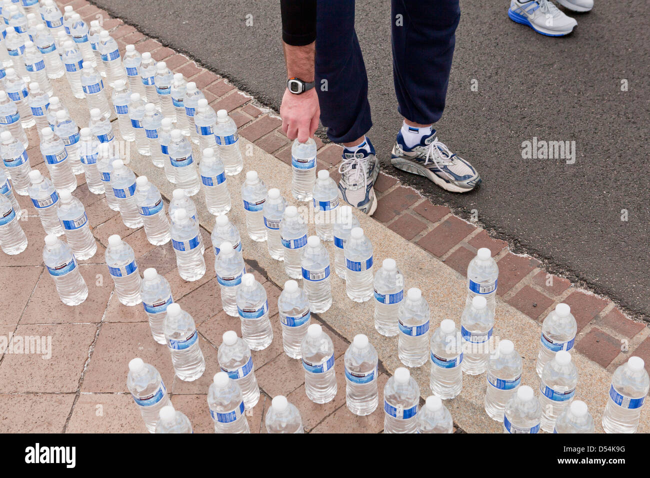 Läufer, die Abholung in Flaschen abgefülltes Wasser nach dem Rennen Stockfoto