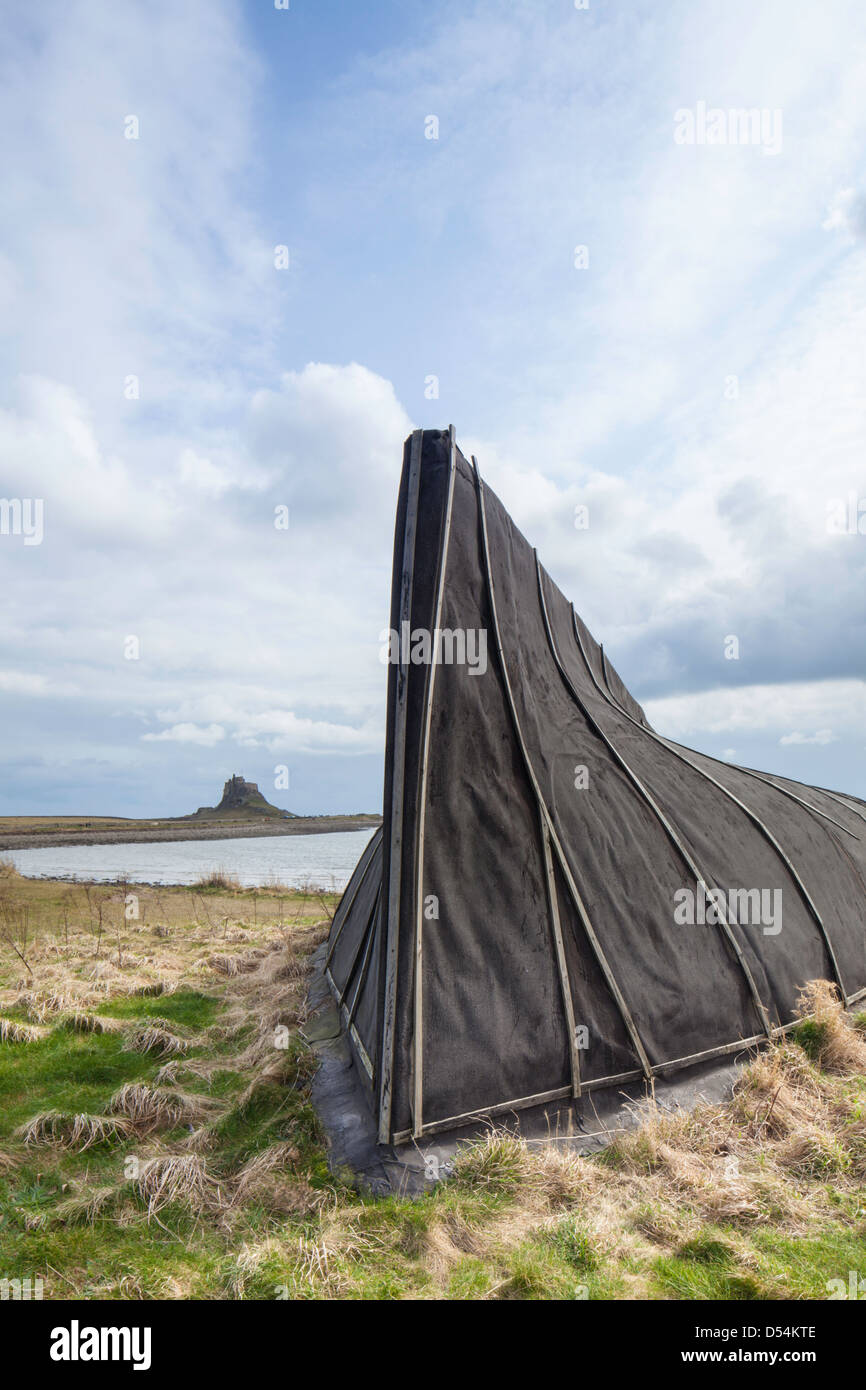 Alten Holzboot wirft mit Lindisfarne Castle in die Ferne, Northumberland, England, UK Stockfoto