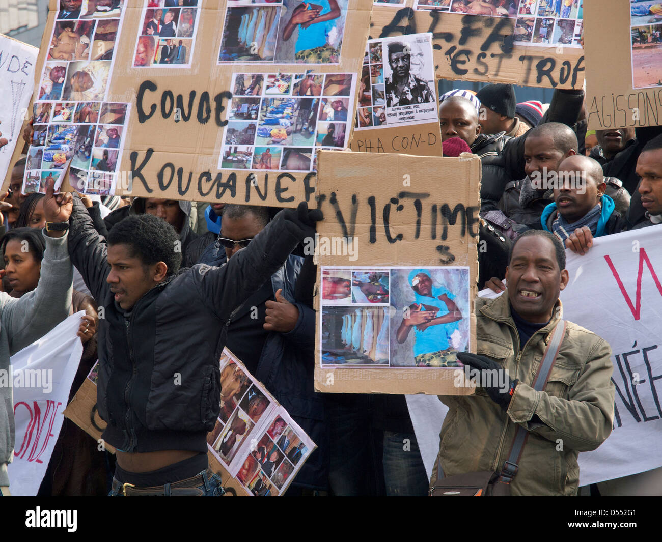 Menschen protestieren gegen Diktator Alpha Conde von Guinea mit Schildern mit Bilder der gequälten Opfer. Brüssel, Belgien Stockfoto